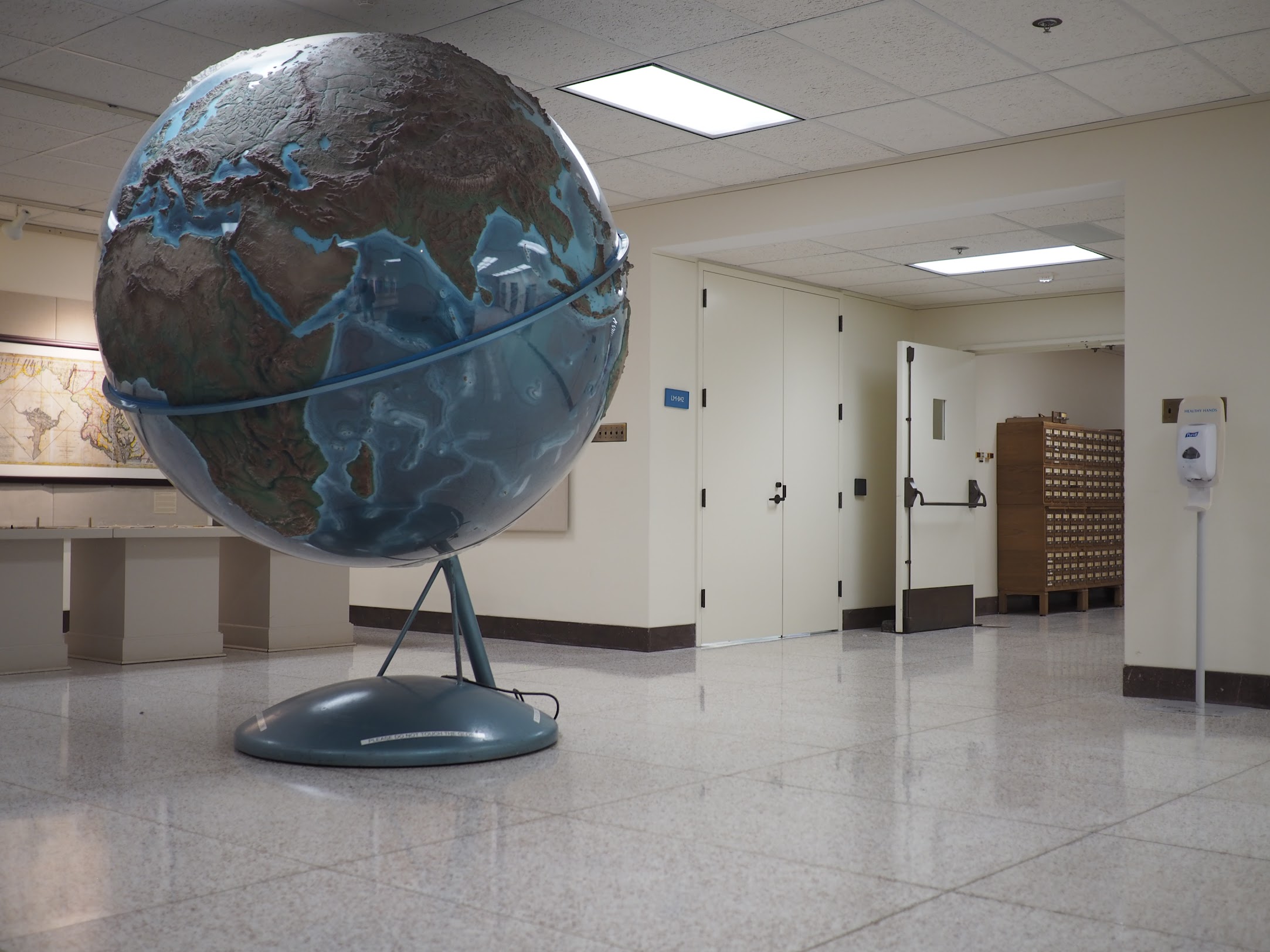 A photograph of a large scultural globe of the world inside of a building with no windows